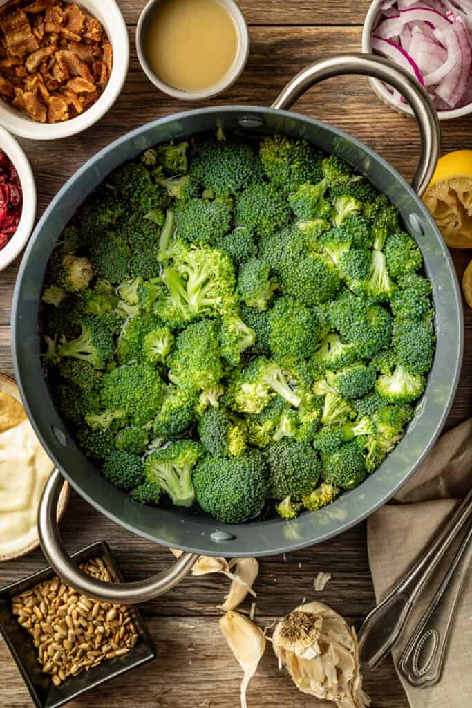 An overview shot of a pan of blanched broccoli on a wood background