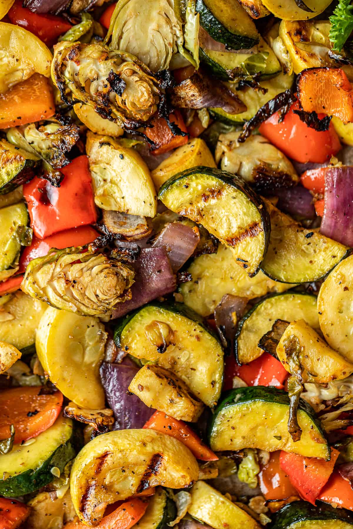 A closeup overview shot of smoked vegetables on a baking dish lined with parchment paper.